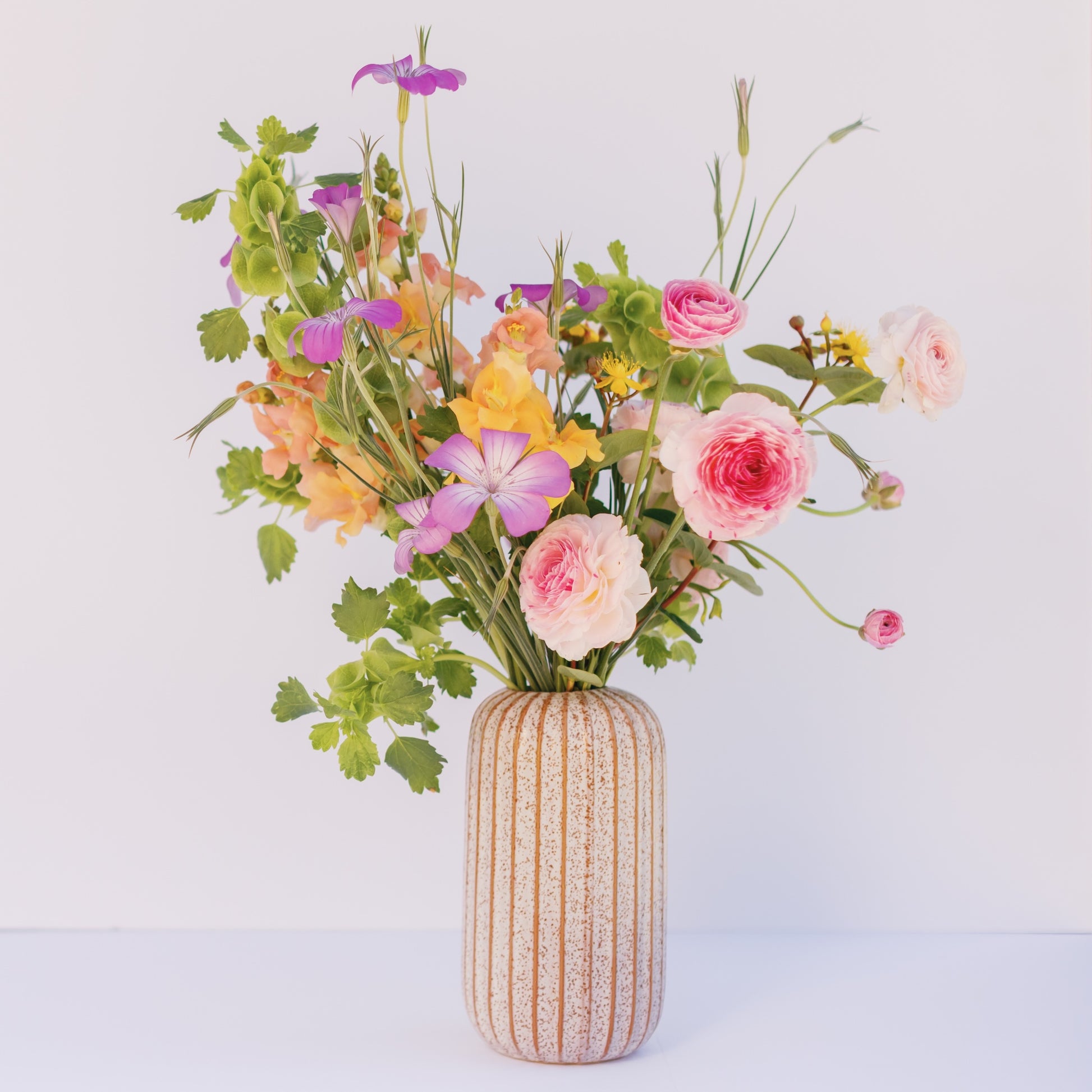 Vase with colorful flowers on a light background