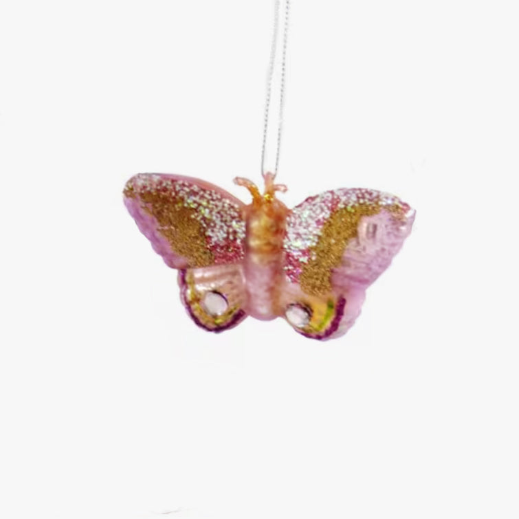 Decorative butterfly ornament with pink and gold wings on a white background
