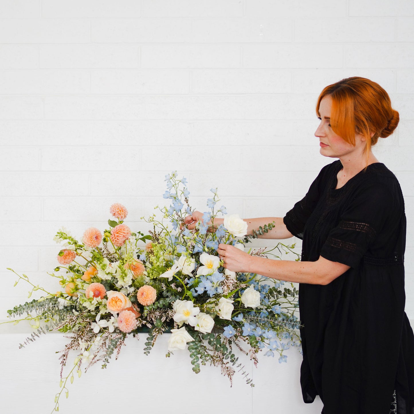 Native Poppy florist adjusts casket spray flowers
