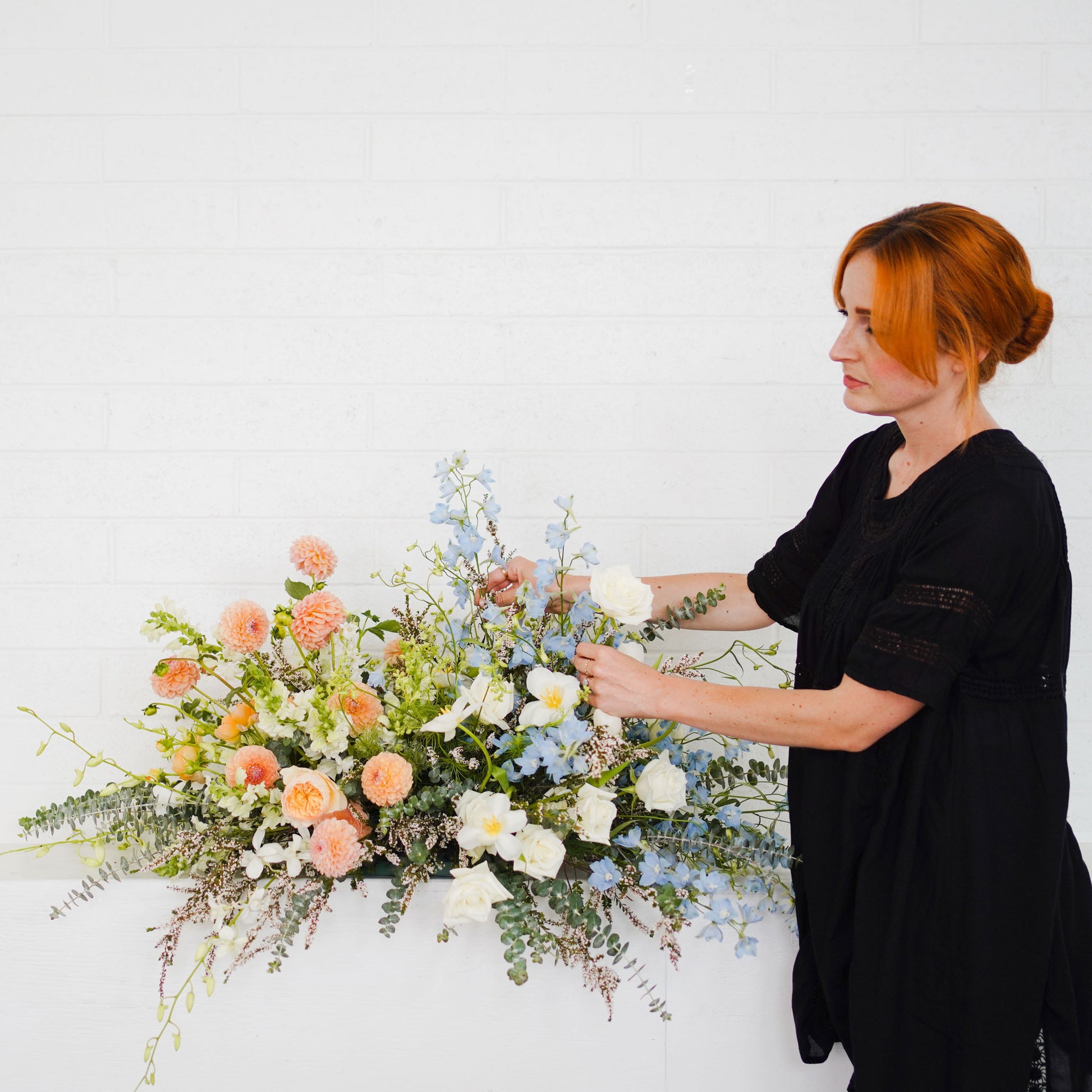 Native Poppy florist adjusts casket spray flowers