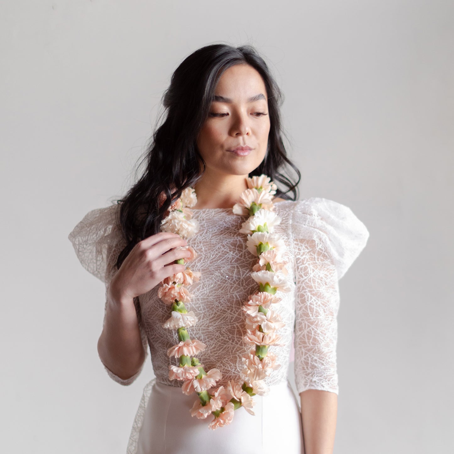 Bride wears a pale pink elegant + neutral flower necklace