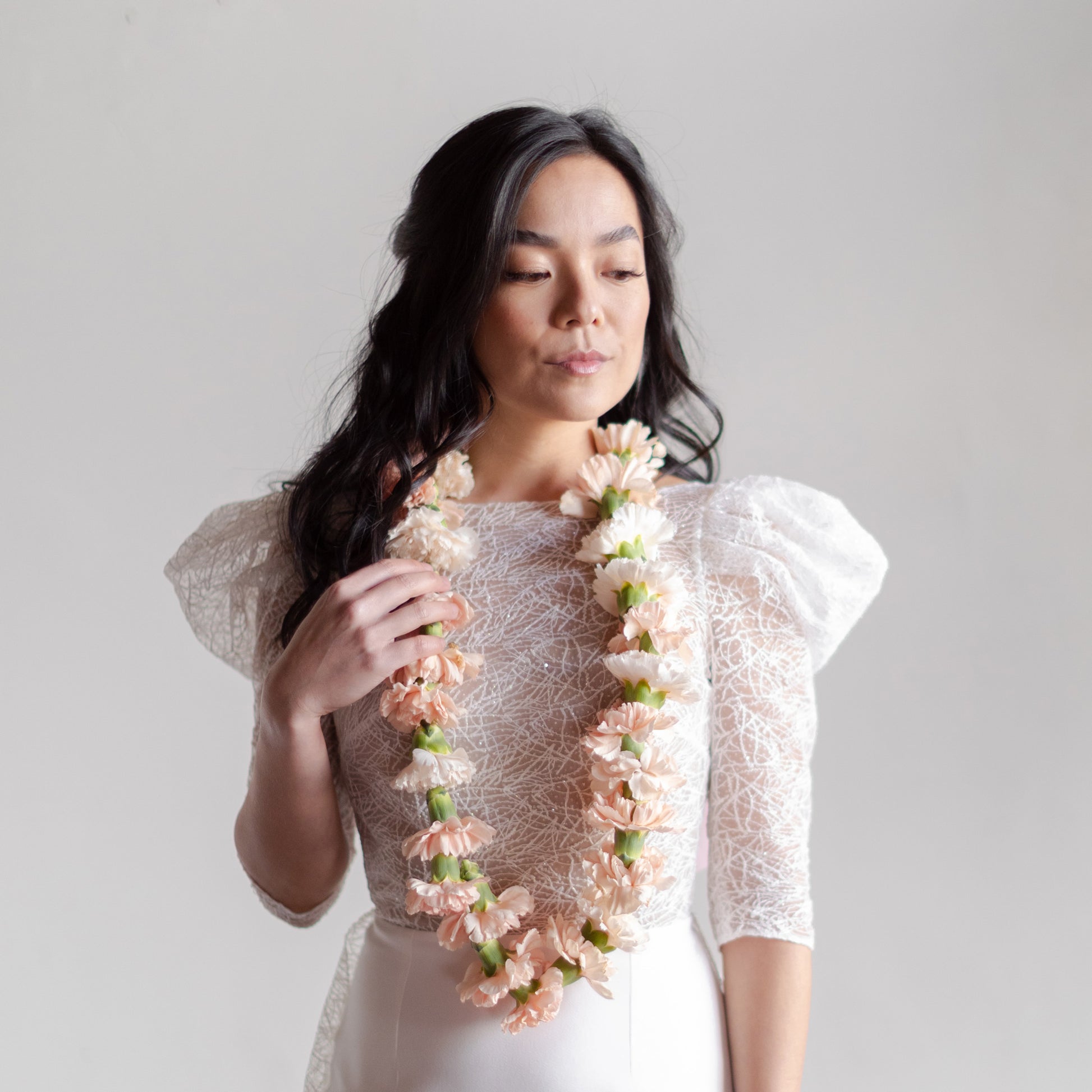 Bride wears a pale pink elegant + neutral flower necklace