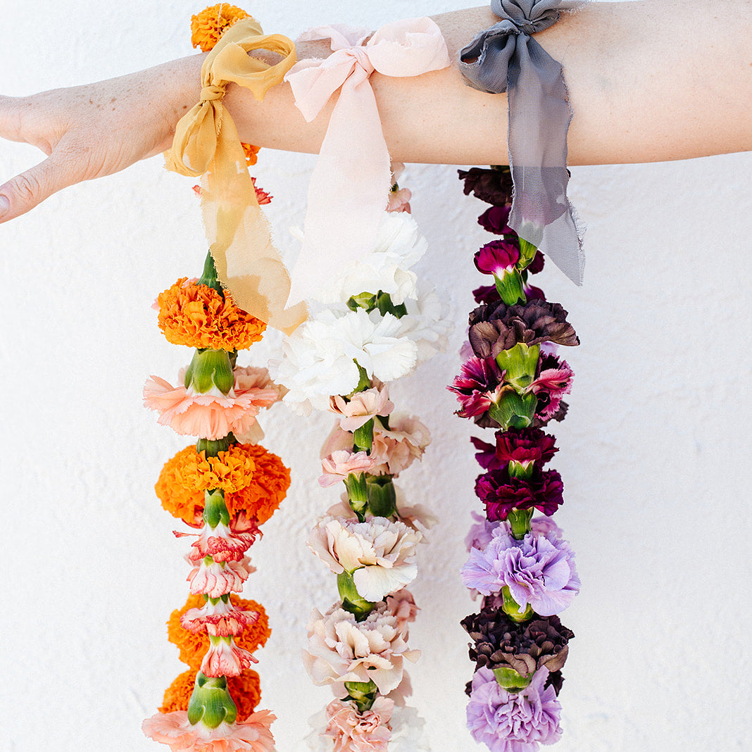 Three multicolored flower necklaces with carnations and marigold flowers