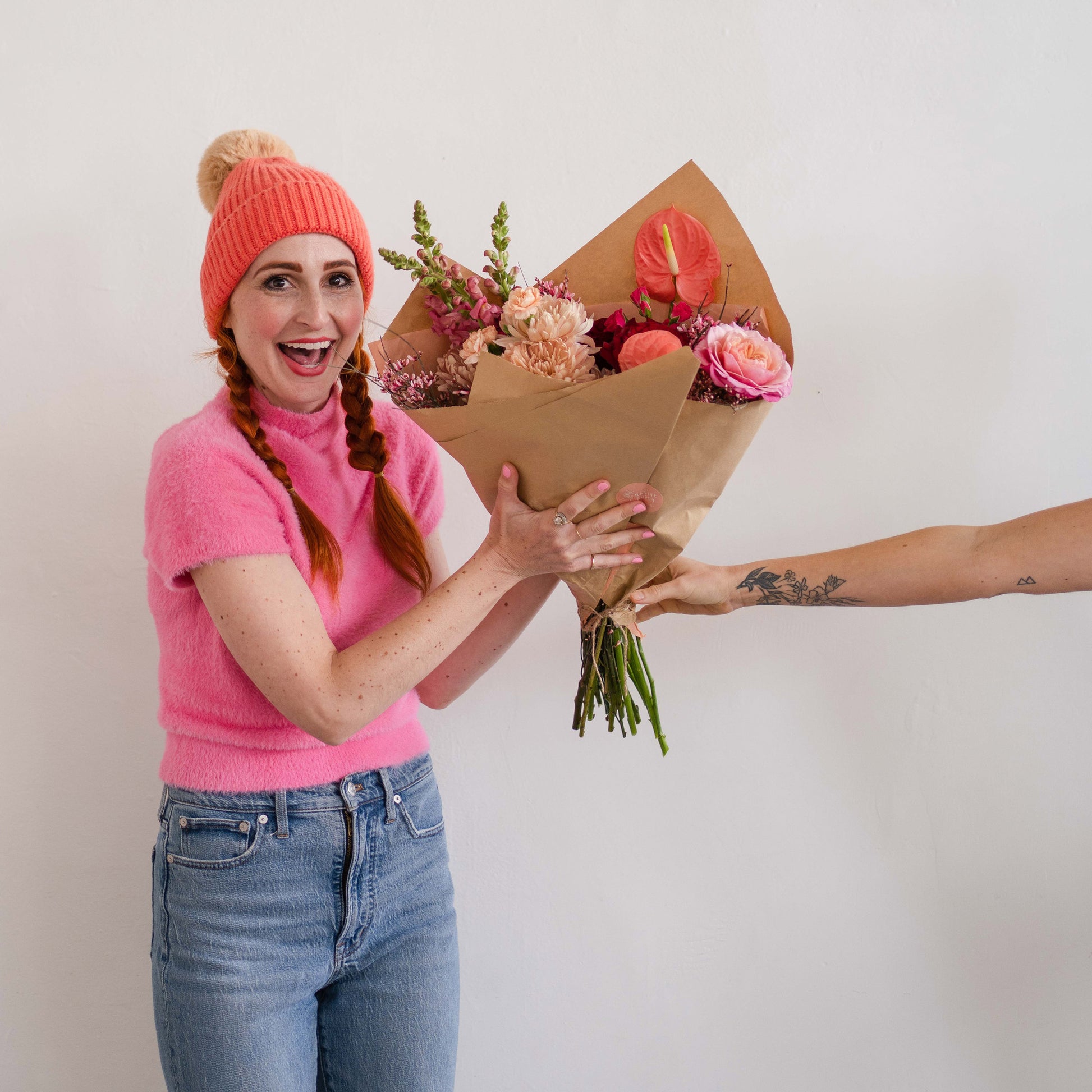 Woman being handed an extra large bouquet of Valentine's Day flowers