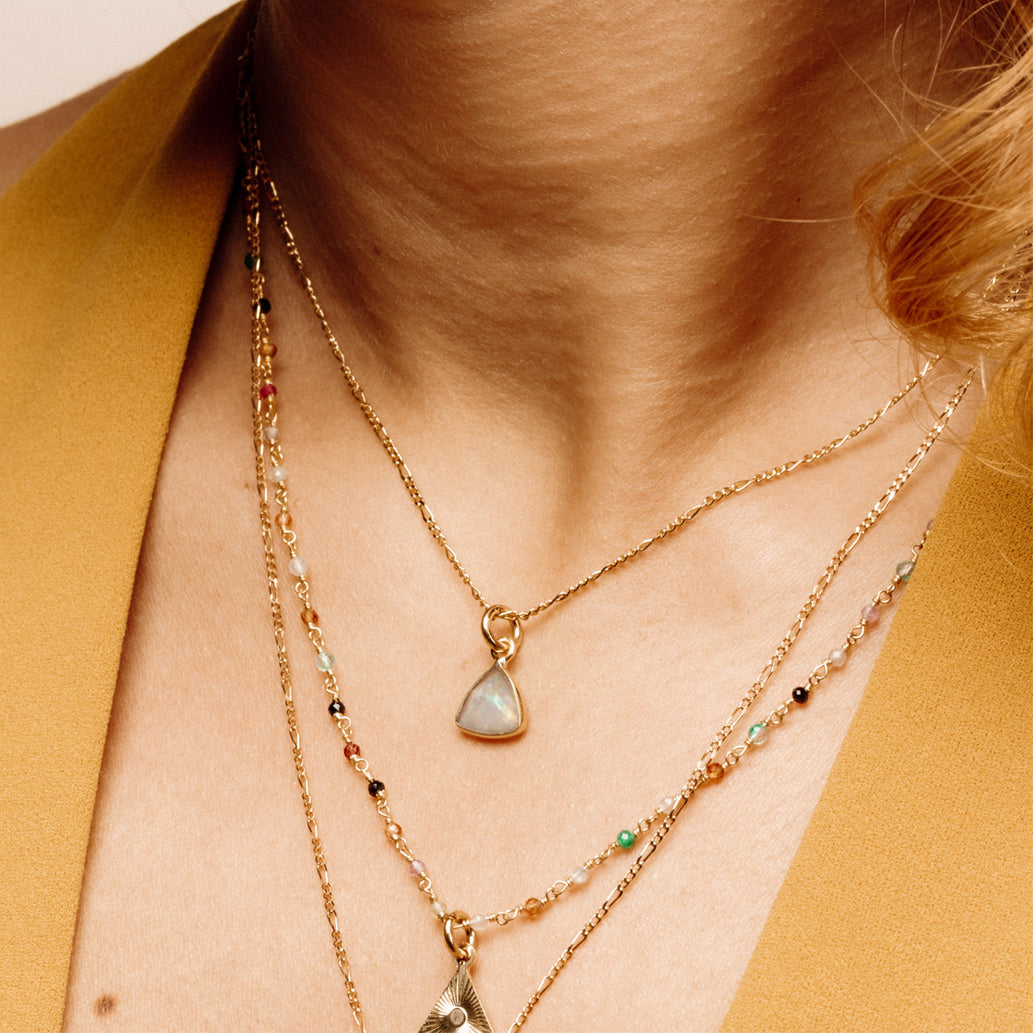 Moonstone triangle necklace on an olive-skinned model