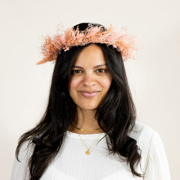 Woman with dark hair wearing peach pink dried flower crown