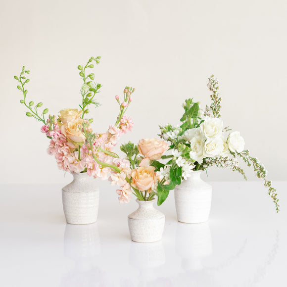 Cluster of ceramic bud vase flower arrangements from Native Poppy in San Diego